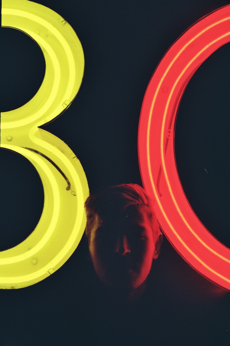 geometric shape, real people, motion, black background, backgrounds, signages, one person, indoors, man, lifestyles, circle, young men, abstract, portrait