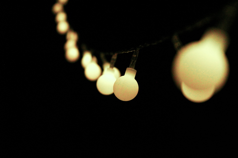 hanging, night, string light, focus on foreground, studio shot, illuminated, personal accessory, indoors, selective, string, light bulb, black background