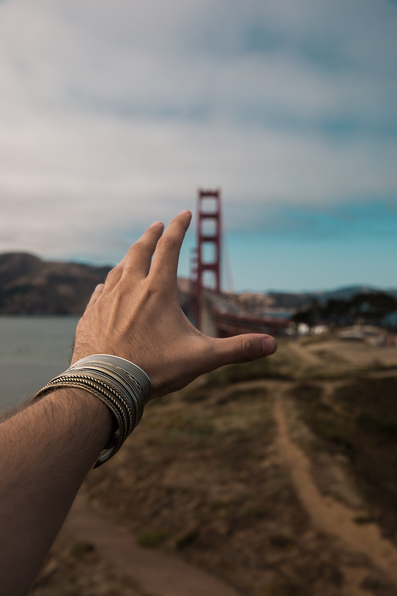 sky, one person, mountain, shallow, left, person, holding, focus on foreground, finger, caucasian, bridge, beach, landscape, photography, reading, real people