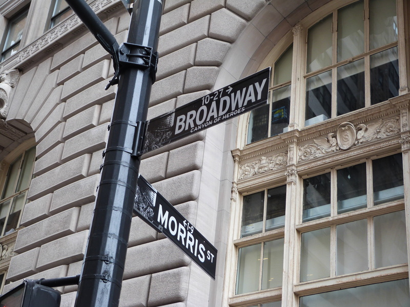 big apple, text, glass - material, information sign, city, low angle view, street sign, outdoors, building exterior, architecture, directional sign, western script