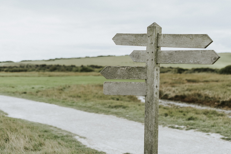 religion, near, distance, wooden, wood, pedestal, focus on foreground, land, direction, cross, symbol, dirt road, nature, environment, landscape, belief