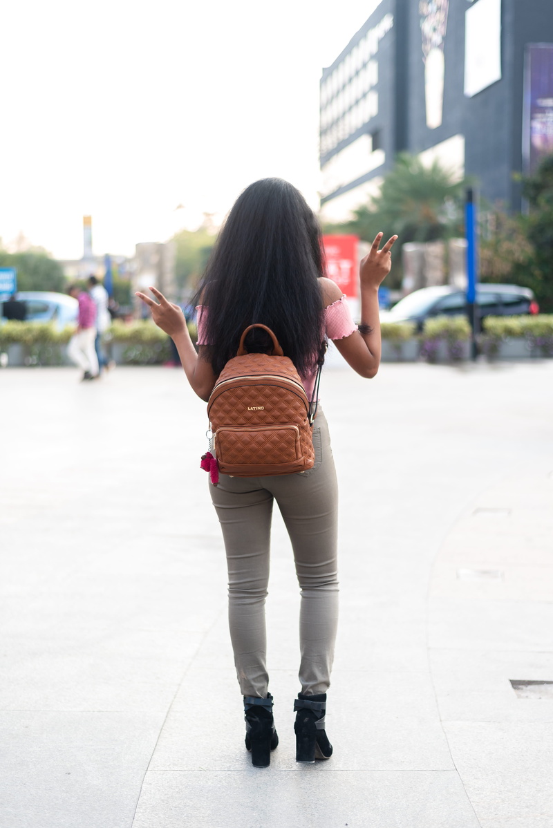 outdoors, model, leisure activity, hair, footwear, standing, apparel, strong, fearless, full length, black hair, fashion, rear view, unique, tough, handbag