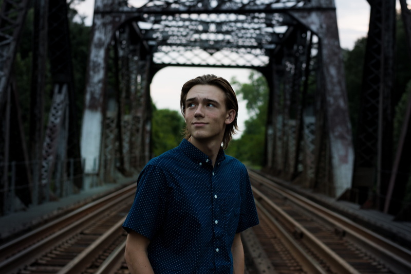 one person, middle, railroad track, male, person, tree, man, adult, hot, day, bridge, structure, transportation, front view, rustic, waiting, real people