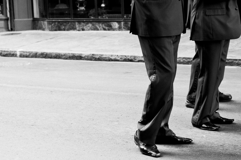 focus on foreground, pants, human foot, wearing, human body part, clothing, fashion, sidewalk, two people, human limb, dress, foot, shoe, uniform, women