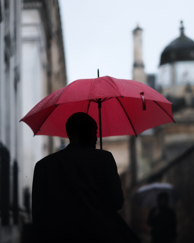 one person, holding, red, people, architecture, umbrella, rain, focus on foreground, security, men, walking, city, building exterior, 4K, adult, incidental people