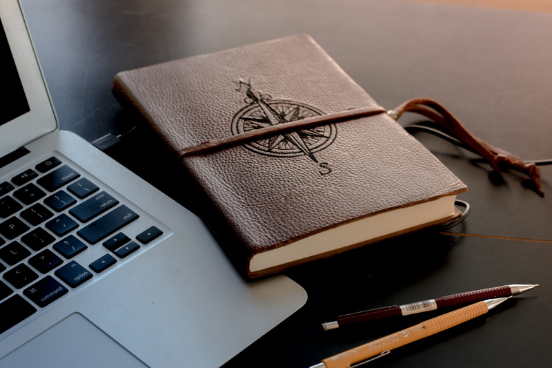 indoors, background, computer, book, communication, compass, no people, desk, furniture, journal, pen, keyboard, diary, brown, publication, high angle view