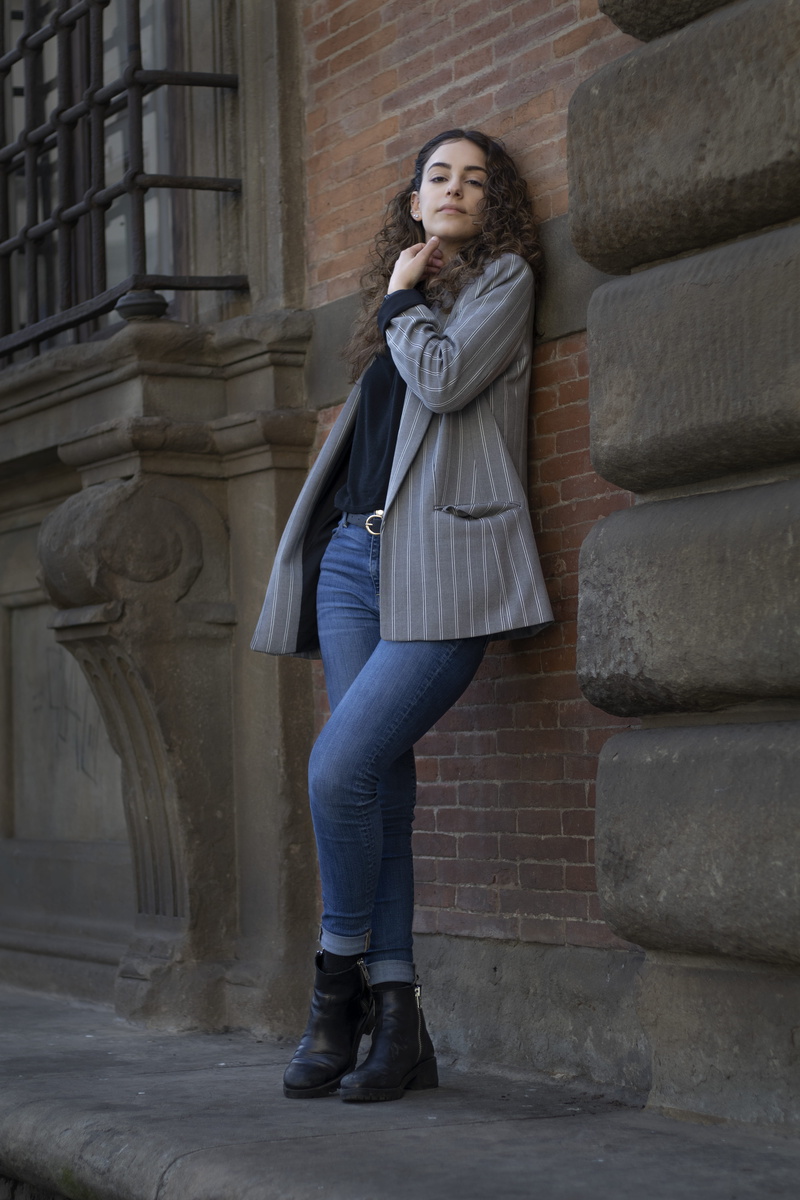 hair, female, casual clothing, strong, sleeve, leaning, wall, front view, standing, lifestyles, built structure, adult, shoe, young adult, coat, overcoat