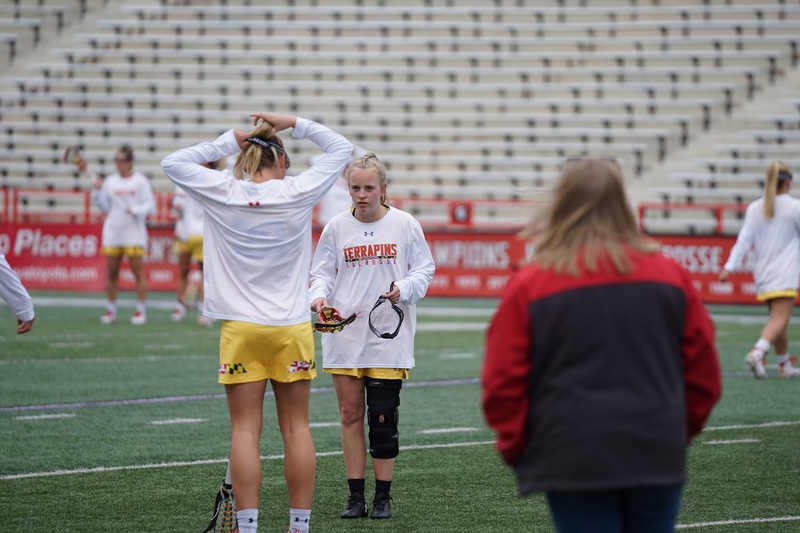 team sport, building, soccer, pants, sphere, team, huddle, clothing, person, shorts, leisure activity, focus on foreground, sports, casual clothing, females