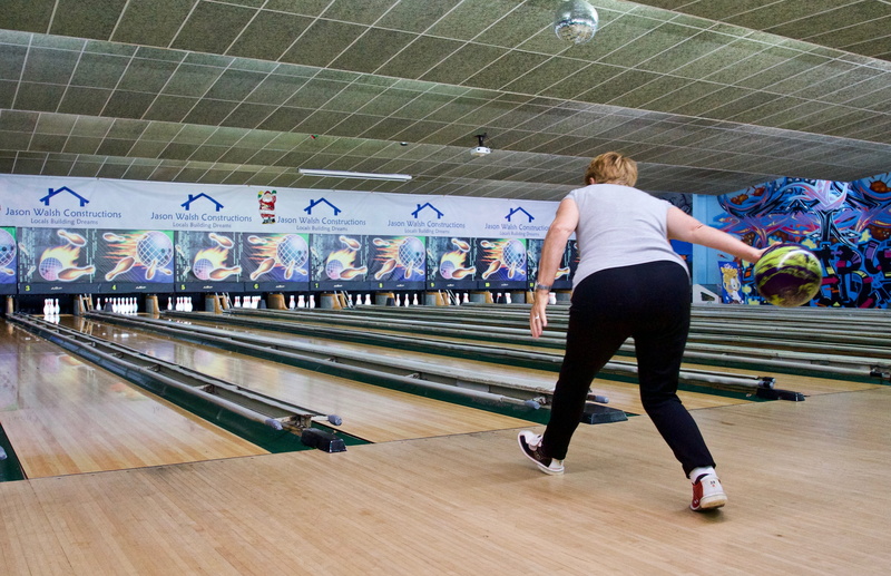 rear view, strike, leisure activity, sport, hairstyle, real people, standing, women, full length, bowling, blond hair, ball, alley, bowler, incidental people