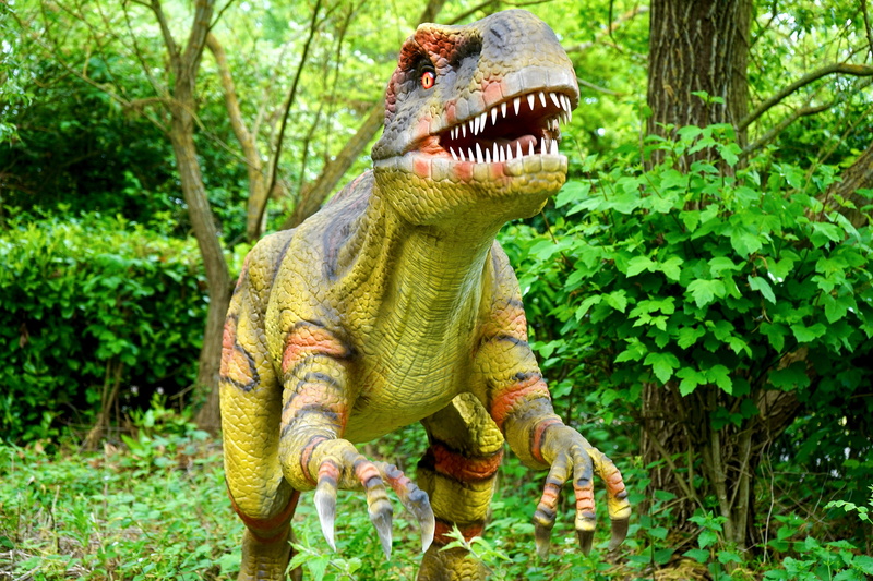 animal representation, dinosaur, green color, animal wildlife, carnivore, aggression, animal themes, plant, dangerous, scary, prehistoric, focus on foreground