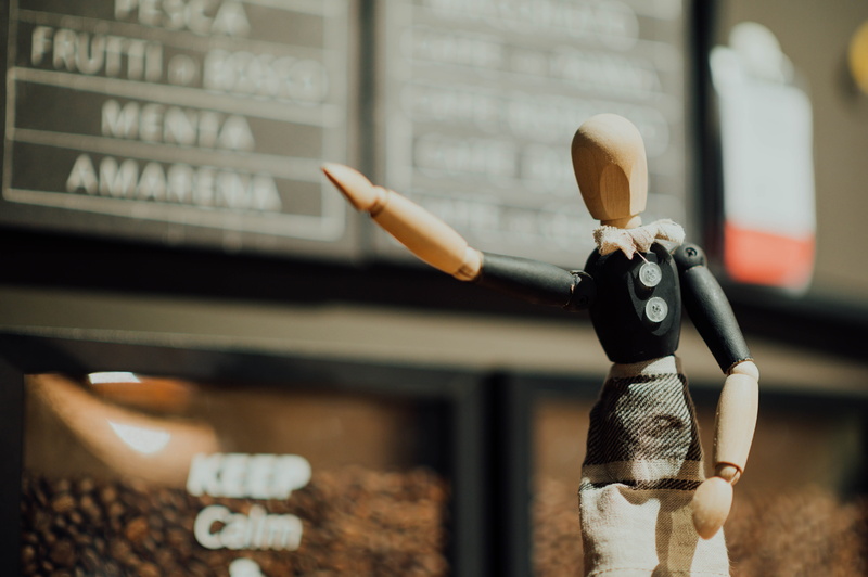 art and craft, wood - material, clothing, mannequin, store, coffee cup, sweets, creativity, figurine, holding, signage, male likeness, representation, toy