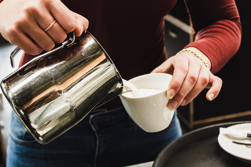 human body part, icing, coffee cup, midsection, pouring, cream, finger, cake, beverage, refreshment, hand, human, creme, person, one person, pottery, real people
