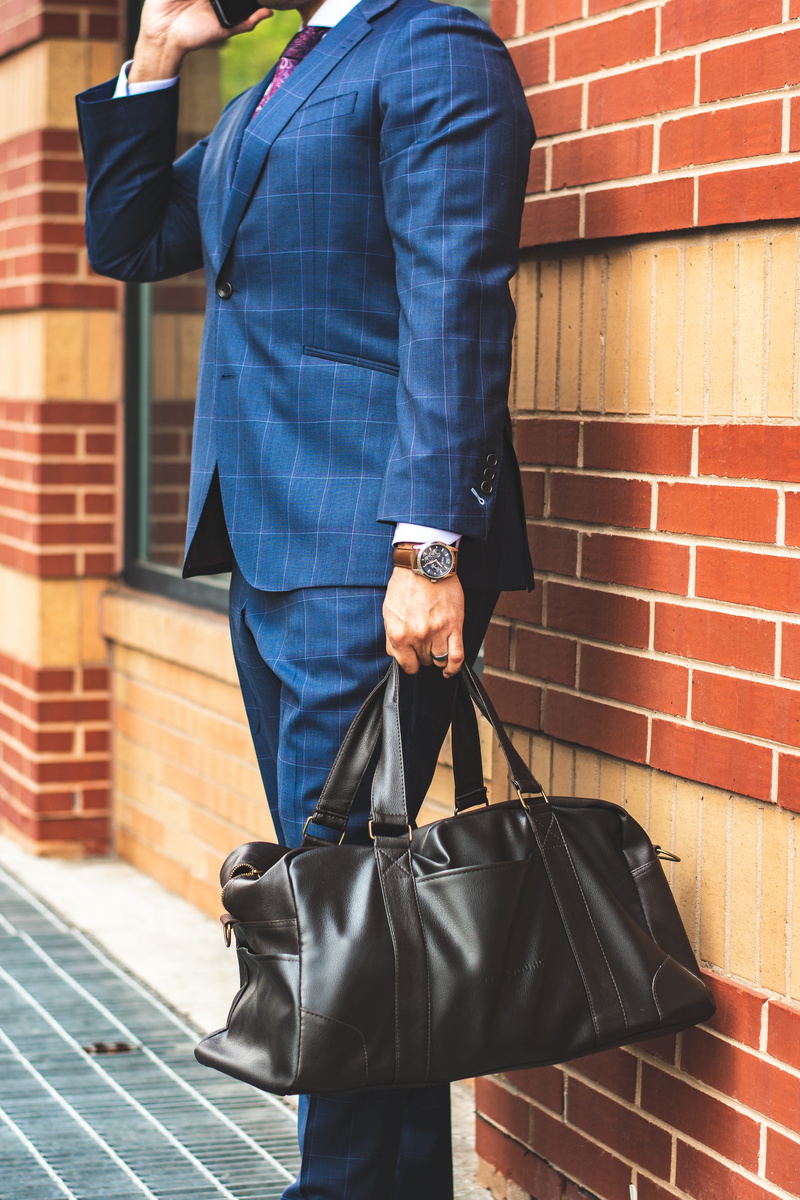 bag, fashion, daylight, holding, phone, corporate, wall, talking, one person, man, standing, suit, watch, street, near, men, lifestyles, concrete, businessman