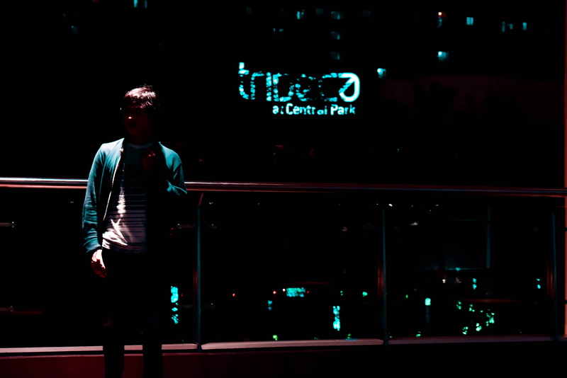 young adult, casual clothing, three quarter length, nightlife, lowkey, illuminated, stand, front view, looking, looking away, real people, architecture