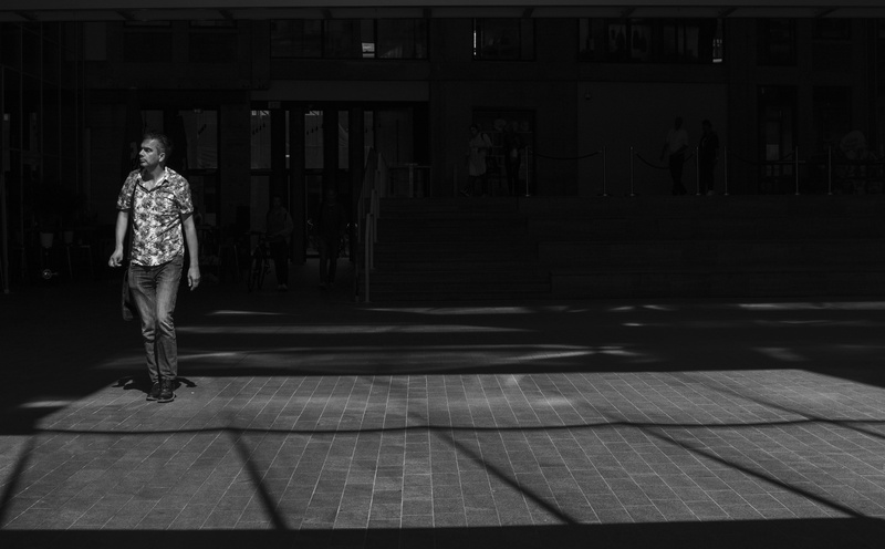 lowkey, one person, wnadering, lost, full length, city, architecture, lifestyles, shadow, sunlight, built structure, leisure activity, contrast, rear view