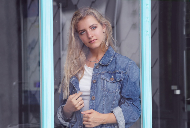 looking at viewer, front view, portrait, young women, beautiful woman, holding, women, looking at camera, blonde, jeans jacket, one person, adult, blue eyes