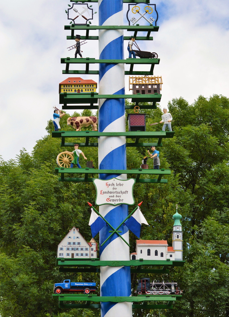 tribe, text, low angle view, day, western script, hanging, setting up, tree, building exterior, built structure, sky, multi colored, maypole set up, plant