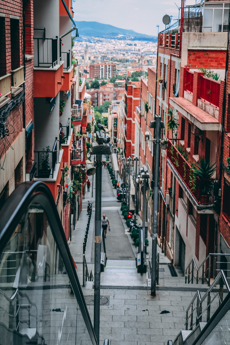 building, sidewalk, high angle view, road, city view, residential district, building exterior, transportation, cityscape, outdoors, colors, people, day