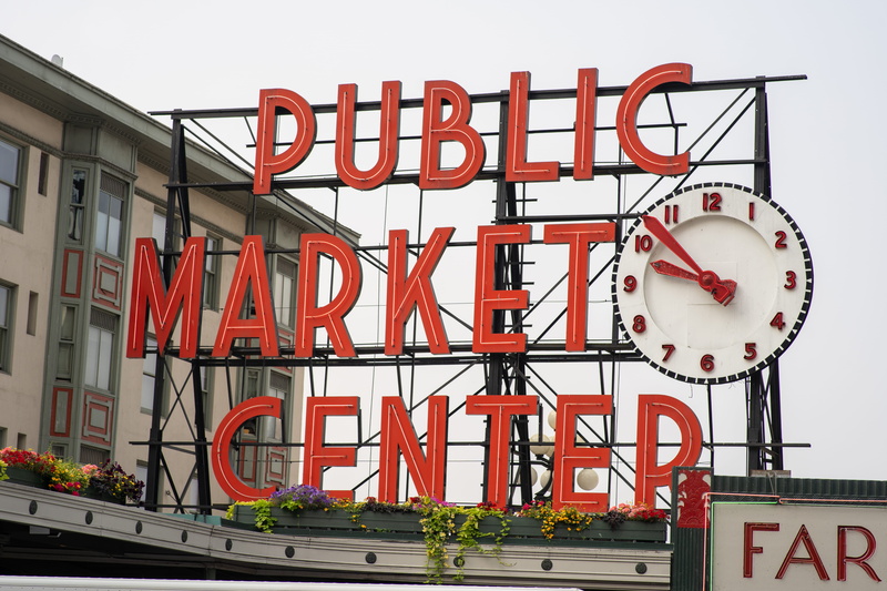 outdoors, built structure, clear sky, western script, information sign, building, sky, information, red, graffiti, communication, neon, no people, pike place market