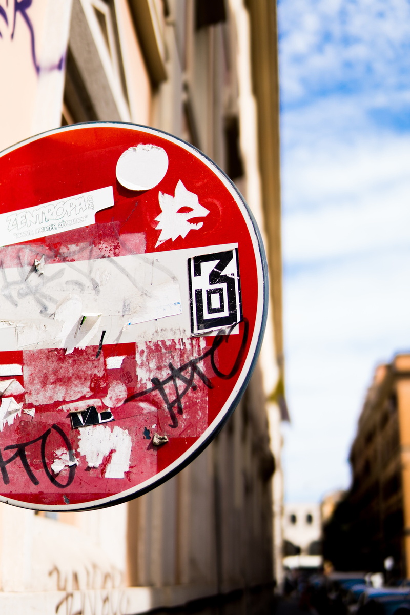 red, focus on foreground, western script, communication, built structure, close-up, circle, architecture, urban, blue, stopsign, sky, italy, rome, outdoors