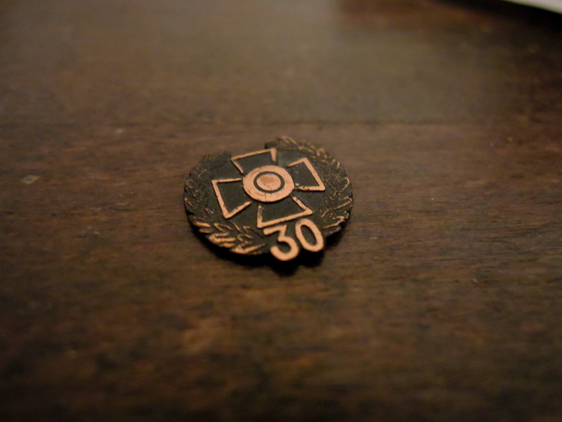 studio shot, emotion, wealth, army, finnish, close-up, bronze medal, indoors, single object, metal, wood - material, representation, text, jewelry, old