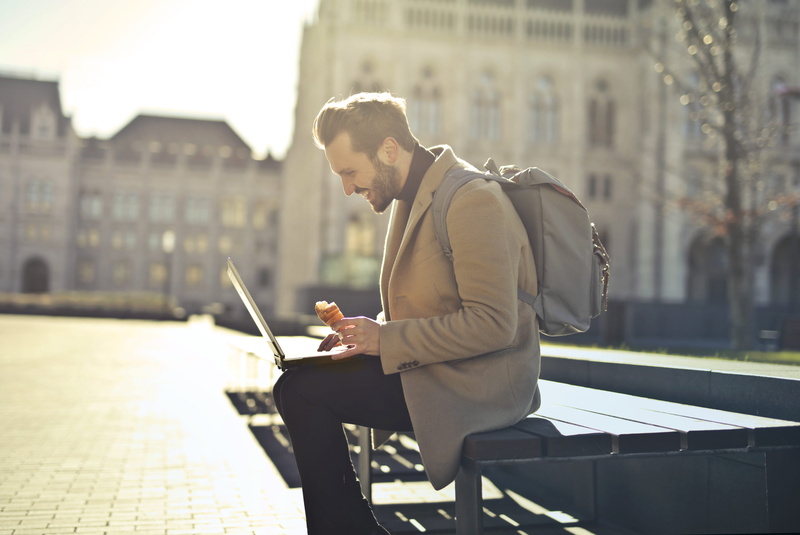 laptop, eating, 5K, wireless, sunlight, connection, outdoor, technology, ice cream, computer, young adult, smiling, food, city life, bench, architecture