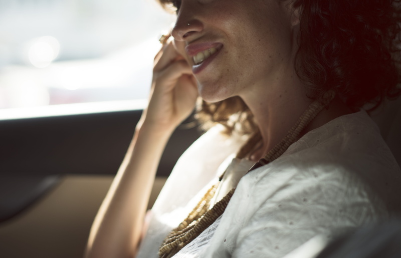 portrait, indoors, talking, emotion, car, facial expression, woman, blur, communication, hand, side view, lips, focus on foreground, face, telecommunication