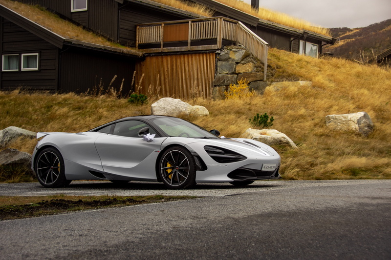 car, cattle, built structure, norway, machine, building, cars, mode of transportation, tire, cow, sports car, sports, outdoors, coupe, luxury, transportation