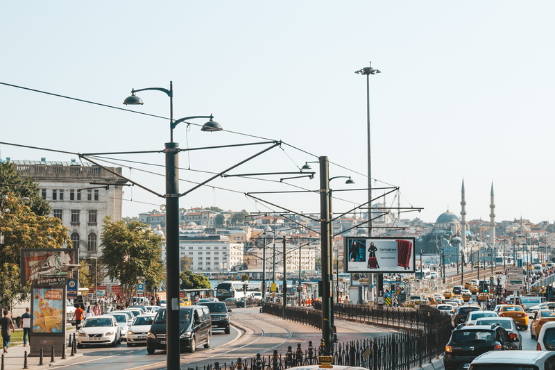 electricity, city, daylight, tram lines, sky, street, people, pavement, road, car, building, city street, transportation, downtown, buildings, 5K, building exterior
