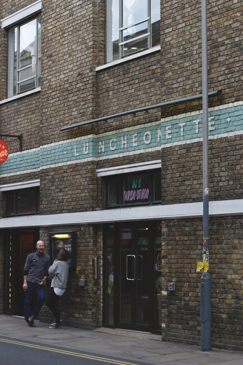 communication, outdoors, building exterior, brick lane, city, two people, lifestyles, people, adult, architecture, real people, window, built structure