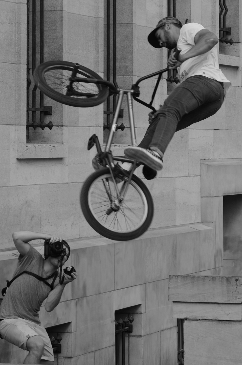 holding, city, casual clothing, architecture, technology, stunt, real people, spectacular, man, withdrawal, skill, cool, bmx, leisure activity, lifestyles