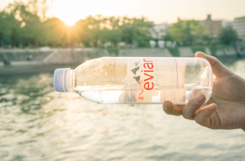 seasoning, human body part, hand, bottle, communication, cosmetics, pop bottle, water, sunlight, light, flare, day, syrup, human, drink, glass, mineral water