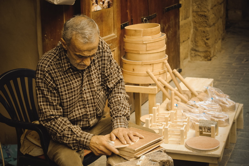 2K, casual clothing, one person, men, working, eyeglasses, males, sitting, real people, chair, senior men, lebanon, market, indoors, occupation, saida