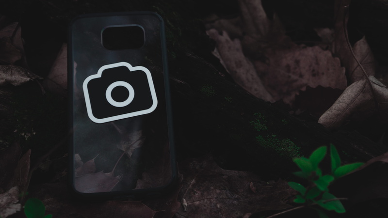 technology, no people, close-up, text, night, number, sticker, outdoors, focus on foreground, phone, nature, sign, rock, solid, leaves, rock formation