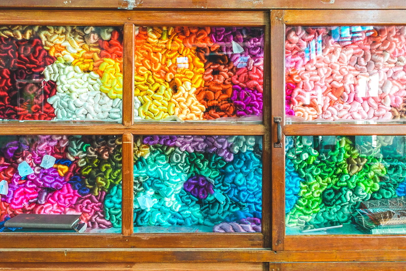 retail display, myanmar, thein nyo silk weaving, business, arrangement, burma, side by side, large group of objects, backgrounds, abundance, indoors, glass - material