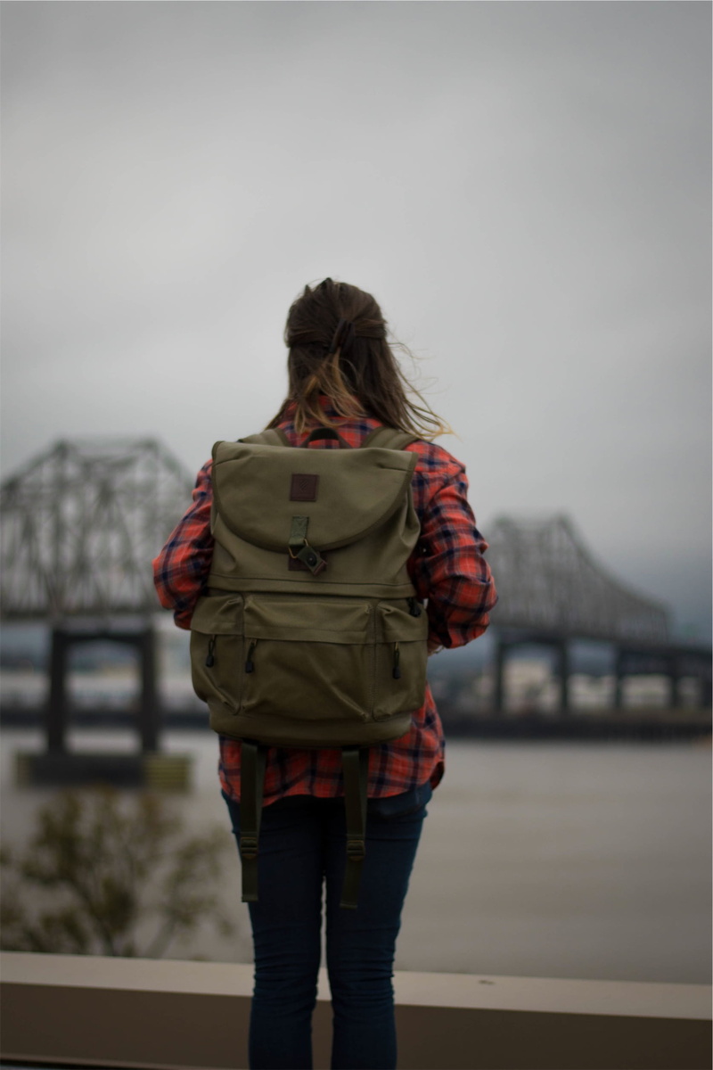 backpack, looking at view, near, sky, focus on foreground, one young woman only, bridge, 1080P, cold temperature, overlooking, lifestyles, rear view, only women