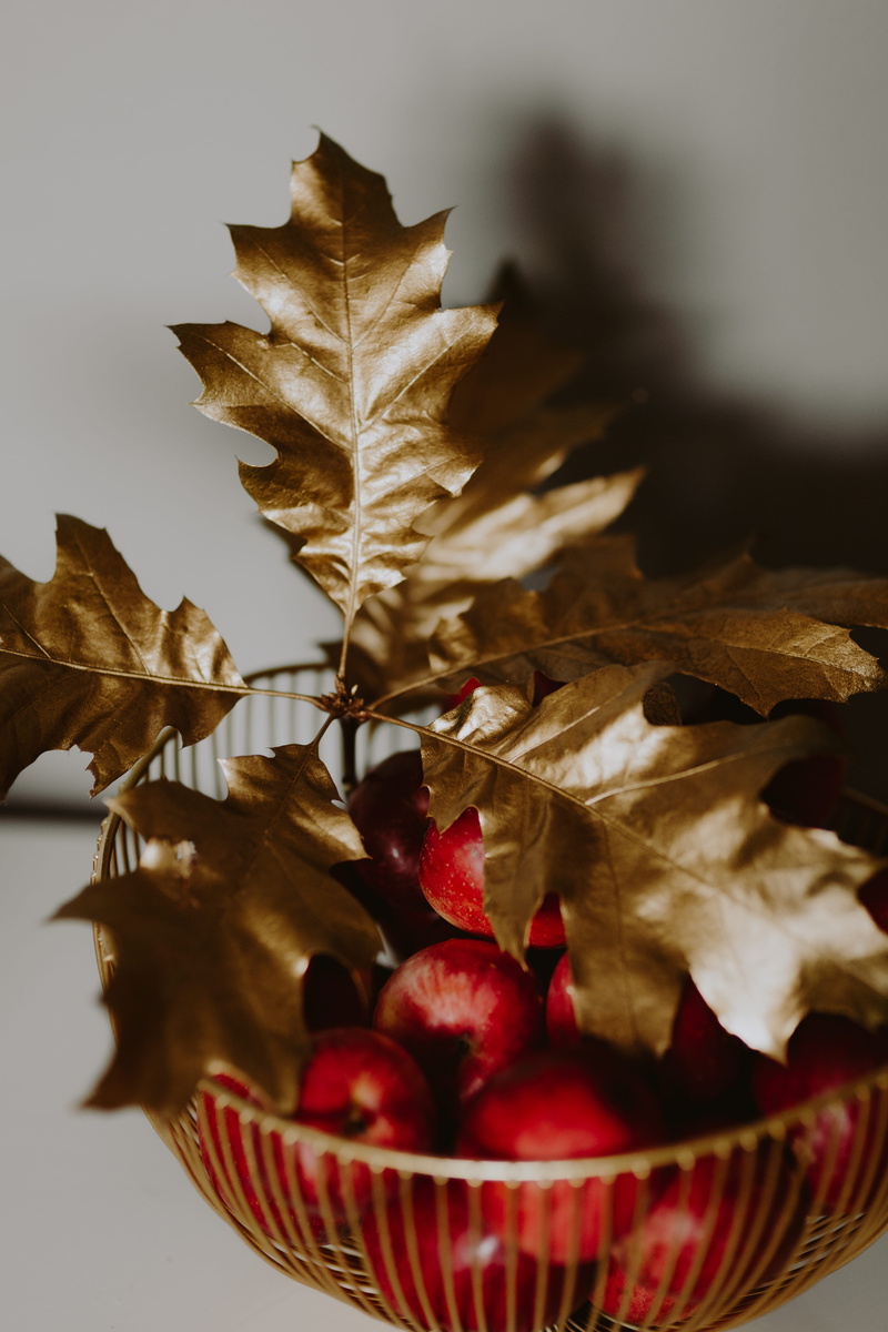 gold leaf, golden, red, indoors, selective focus, close-up, oak, gold oak, red apple, golden leaf, dry, table, gold decor, 5K, leaf, focus on foreground