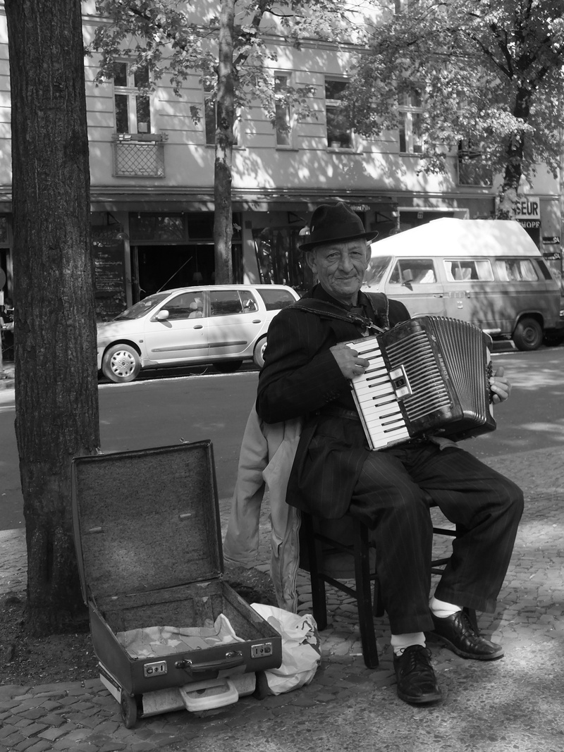 motor vehicle, street musicians, older gentleman, men, accordion player, transportation, males, one person, building exterior, mode of transportation, lifestyles