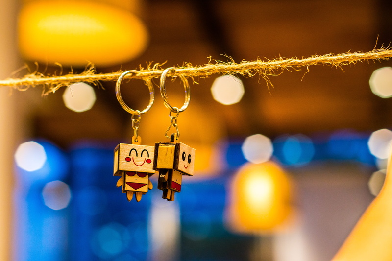 couple, shallow, focus on foreground, toys, outdoors, communication, love, group of objects, colors, photography, keychain, luck, bright, security, city