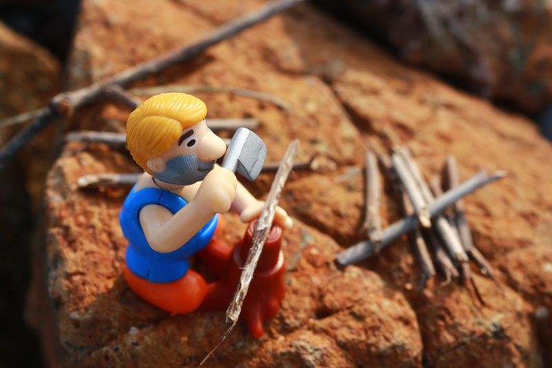 human representation, brown, selective focus, one person, blue, childhood, day, rock - object, lumberjack, sitting, focus on foreground, plastic, nature