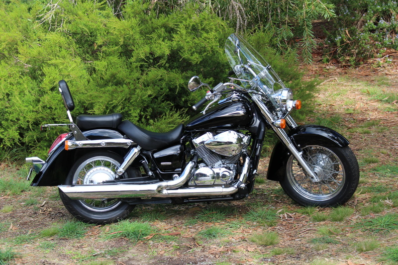 honda motorbike, parking, side view, no people, honda shadow, field, metal, classic motorcycle, plant, vt 750c, touring bike, land, growth, outdoors, honda