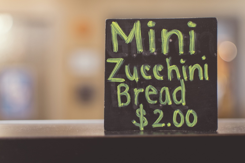 number, indoors, message, illuminated, communication, sign, focus on foreground, cafe, font, alphabet, blur, menu, wood - material, food, green color, bakery
