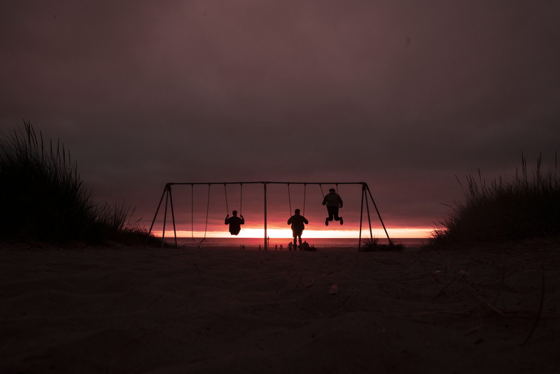 playing, horizon line, outdoors, real people, land, friends, beach, three, oregon, person, men, net - sports equipment, scenics - nature, swing, exploe