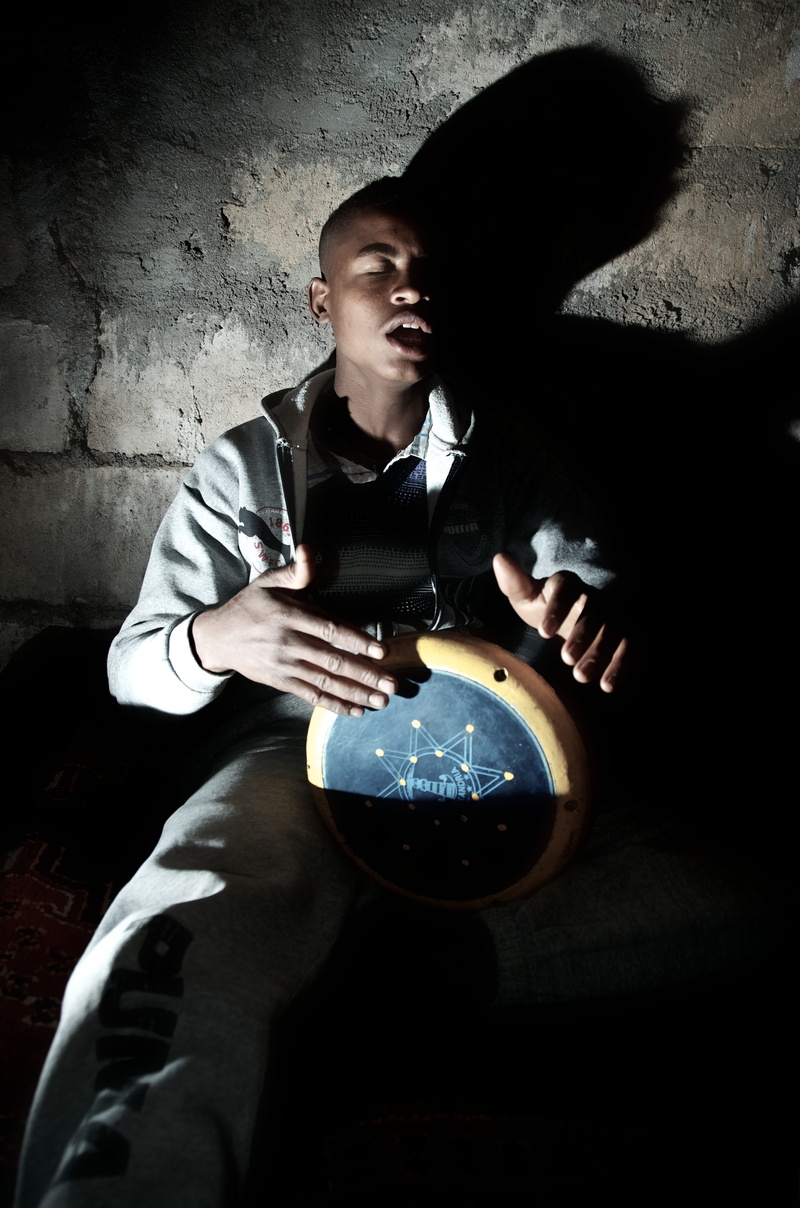 wall - building feature, sitting, bang, males, holding, drum, percussion, concentrate, black, people, real people, beat, instrument, singing, leisure activity