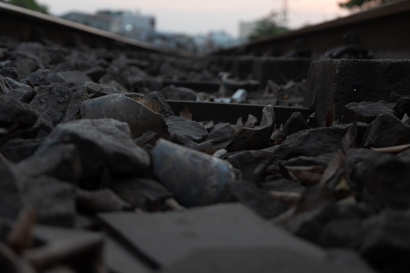 large group of objects, mode of transportation, railroad track, rail transportation, building, environment, track, rubble, cemetery, metropolis, road, metal