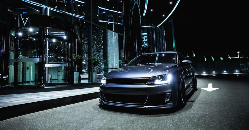building exterior, gray, headlight, land vehicle, luxury, front view, lighting equipment, stationary, illuminated, no people, mode of transportation, parking garage