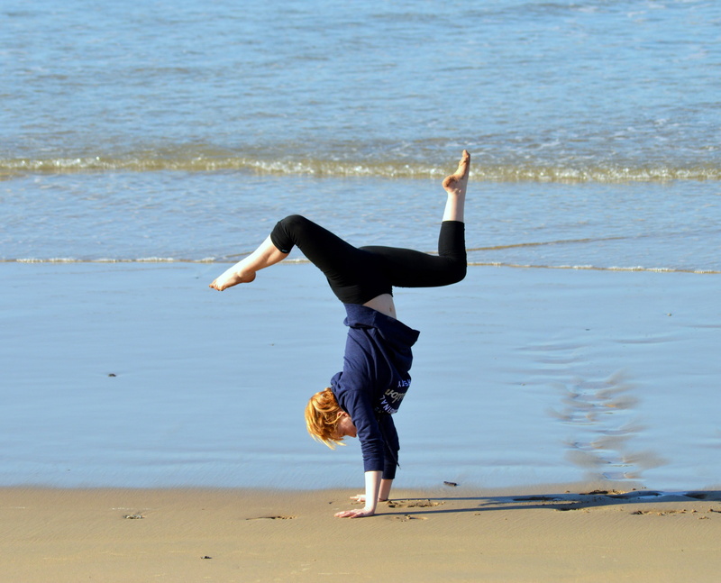 outdoors, nature, day, leisure activity, rear view, sand, motion, girl, seaside, skill, real people, lifestyles, hairstyle, water, sea, body and spirit harmony