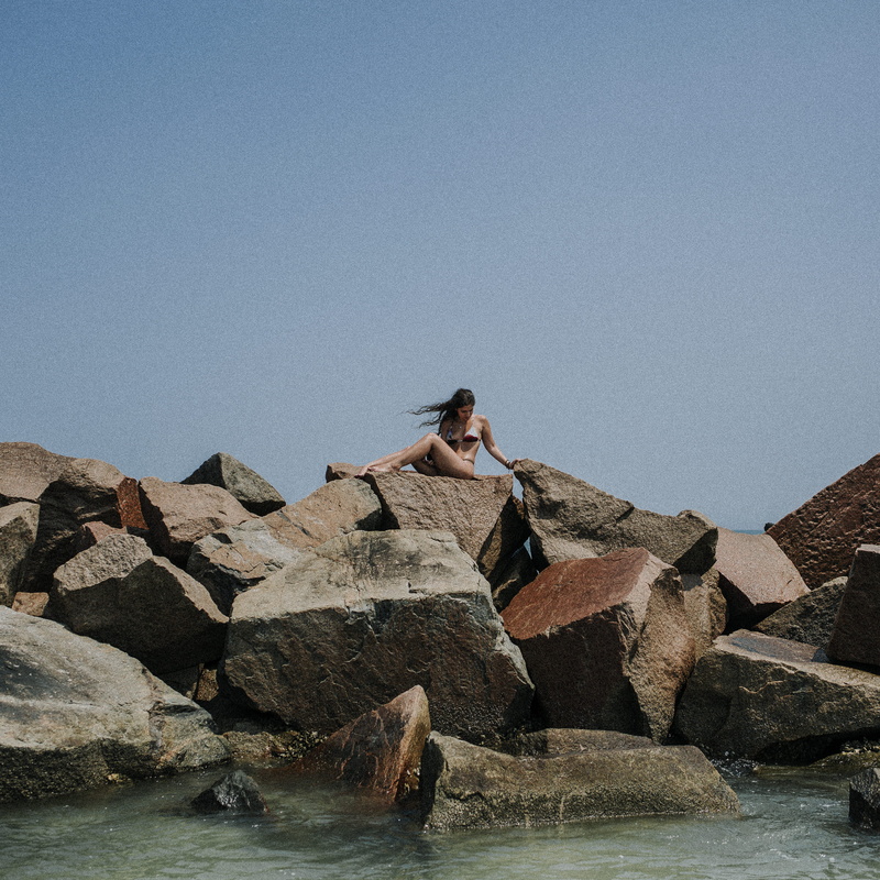 leisure activity, beauty in nature, hair, grain, rock - object, summer, real people, water, blue, wind, bathing suit, rock, outdoors, sky, sea, edit, copy space
