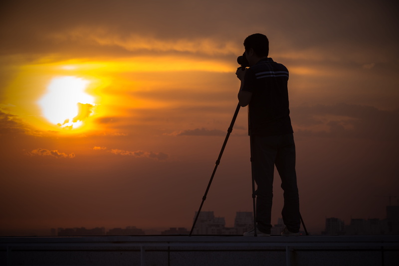 sun, lifestyles, cloud - sky, dusk, silhouette, evening, outdoors, back Lit, shooting, photographer, Sunset, one Person, people, taking pictures, beauty in nature