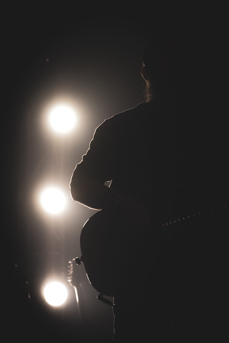 illuminated, silhouette, lifestyles, dark, women, side view, hodling, light - natural phenomenon, lighting equipment, portrait, indoors, guitar, one person